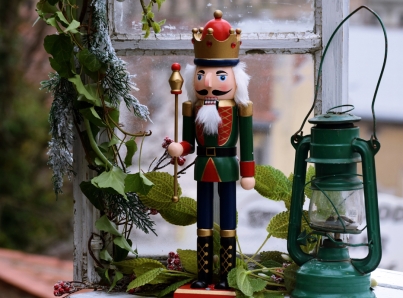 A holiday display that features a vintage nutcracker and antique kerosene lantern